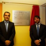 Iván Ballesteros y el doctor Belda posan ante la placa en honor a Seve Ballesteros en el CNIO