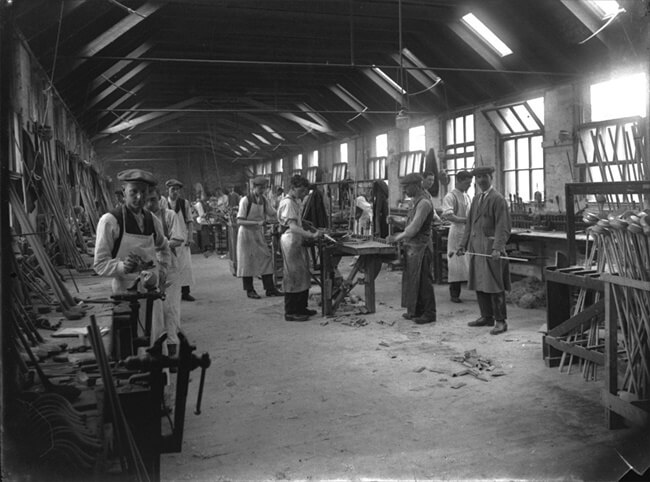Imagen de un fabricante de palos británico alrededor de 1915. EL aspecto era similar a una gran carpintería, donde se ven aprendices y oficiales, y en primer término a la derecha el Clubmaker.